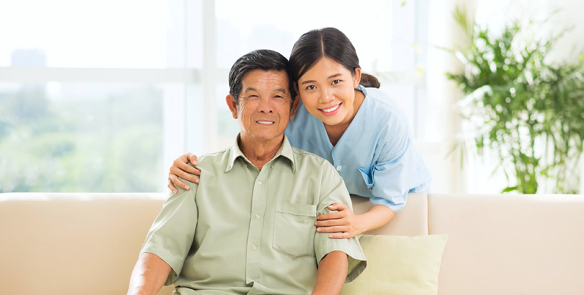 elder man sitting on a couch with caregiver